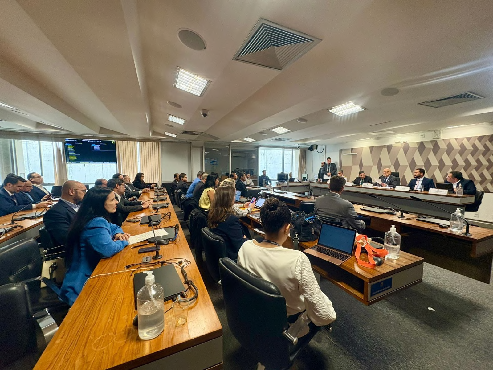 Wide view of participants seated around the meeting tables.